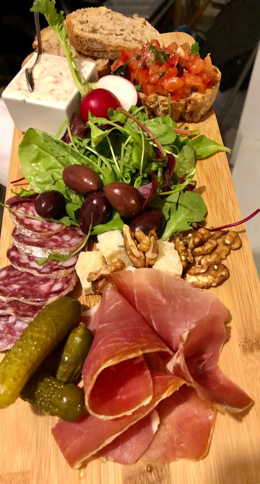 Planche charcuterie fromages avec cornichons et noix